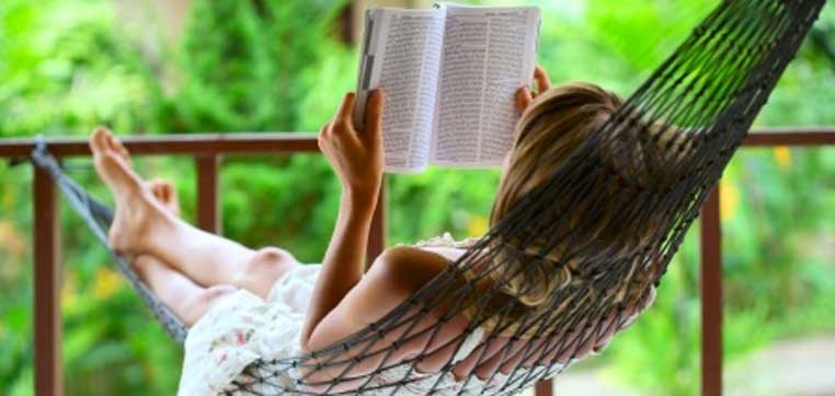 A person relaxes in a hammock surrounded by green foliage, reading "The College Solution" book review.