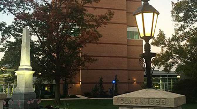 A historic brick building with large windows is framed by trees and a lamp post. In the foreground, there is a stone monument inscribed with "CLASS 1888," showcasing a slice of Millersville University of Pennsylvania’s rich history, as reflected in its common data set.