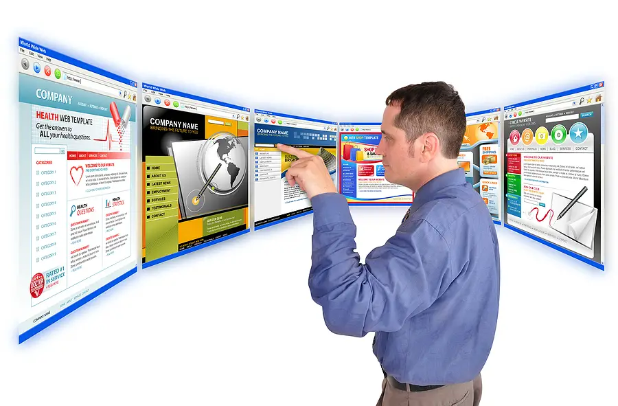 A person in a blue shirt points at multiple floating webpages displayed on screens in front of them, depicting various website designs and layouts for college search websites.