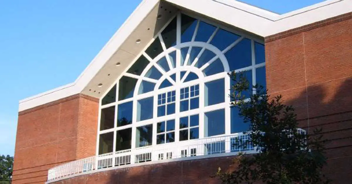 A large brick building at Penn State Behrend College boasts a white, arched window design at the front, featuring multiple rectangular window panes, all under a clear blue sky.