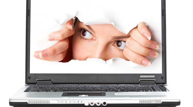 Person looking out of computer screen for good colleges