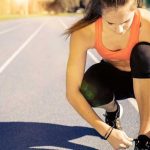 Female athlete tying shoe representing the start the college recruiting process