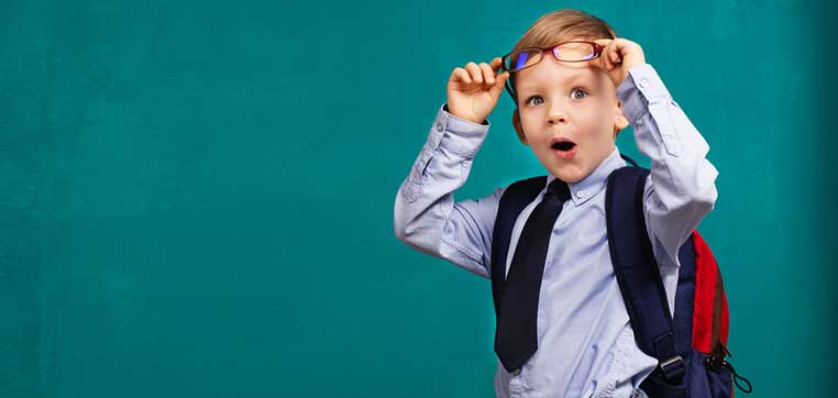 little kid with backpack in front of blackboard representing wealth advantage in college admissions