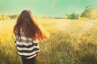 Back of teen standing in meadow representing when the 99th percentile isn't good enough