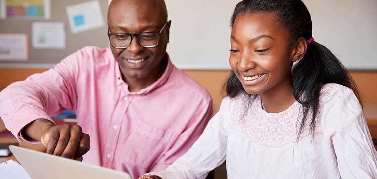 Father helping daughter with test prep decisions on laptop