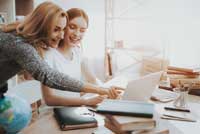 Mother and daughter reading starter custom college list on computer