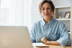 Woman looking at a college spreadsheet on a laptop