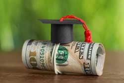 Graduation caps and roll of money representing 3 cheapest colleges by graduation rates