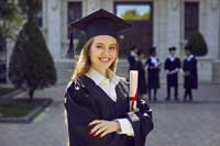 Female graduate student holding diploma representing cheapest colleges by acceptance rates